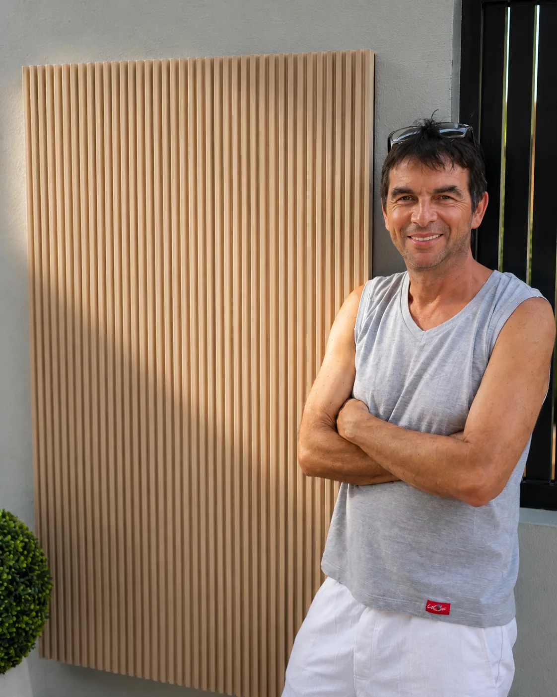 The founder beside the finished fluted cover panel at the G28 villa entrance