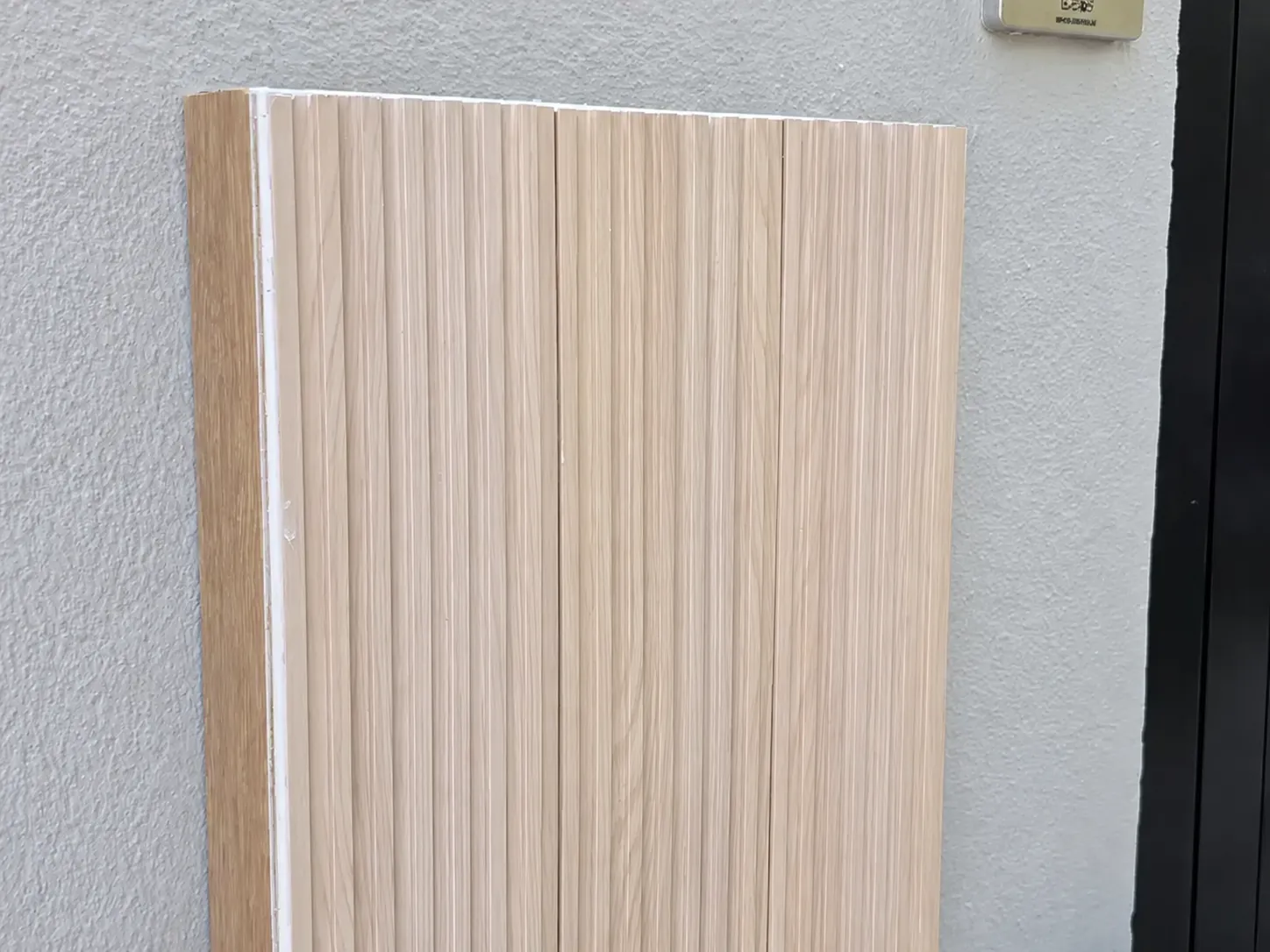 The same cabinet concealed behind a fluted sand-coloured cover panel